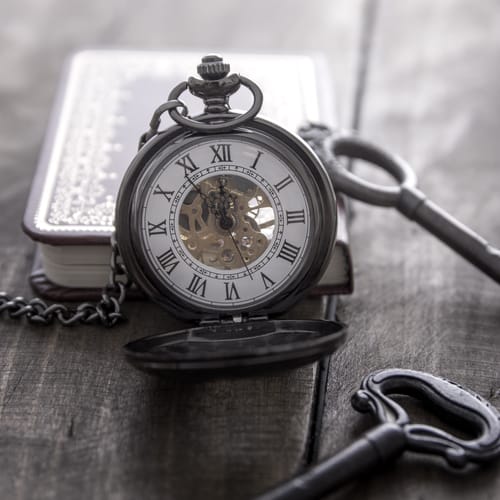 pocket watch on grunge wooden table, close up